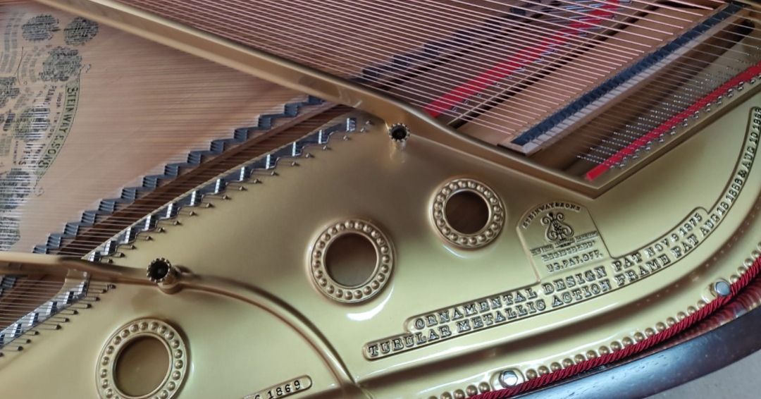 Dettaglio della ghisa dorata di un pianoforte Steinway & Sons del 1869 dopo il restauro, con corde e caviglie nuove